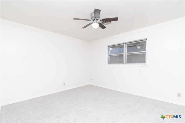 carpeted empty room featuring ceiling fan and crown molding