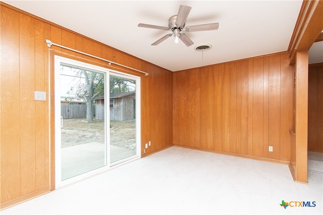 unfurnished room with wood walls and ceiling fan