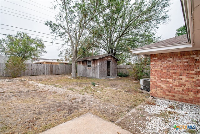 view of yard with cooling unit and a storage unit