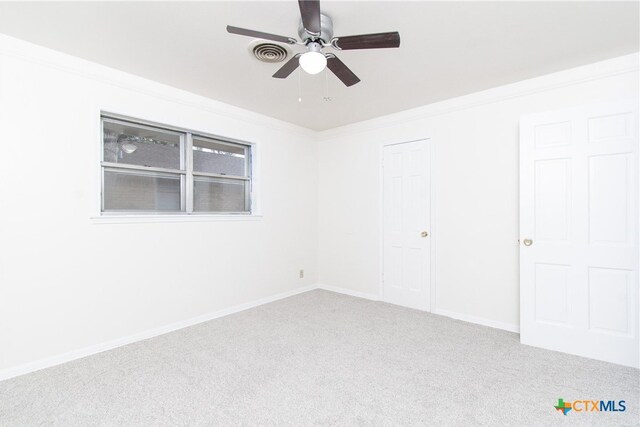 spare room with ceiling fan, carpet floors, and ornamental molding