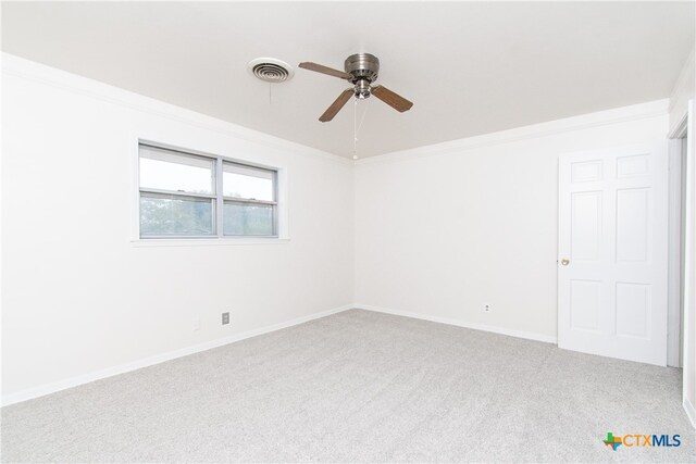 empty room with ceiling fan, ornamental molding, and carpet floors