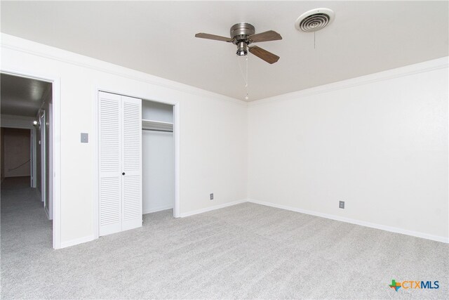 unfurnished bedroom featuring ceiling fan, light carpet, and a closet