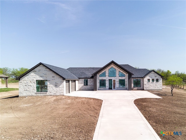 549 County Road 3152, Kempner, TX 76539 - rear view of house with stone siding, concrete driveway, and a garage