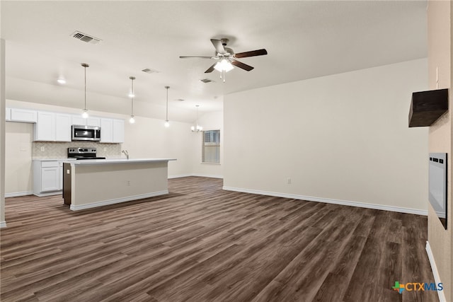 unfurnished living room featuring dark hardwood / wood-style floors, sink, and ceiling fan with notable chandelier