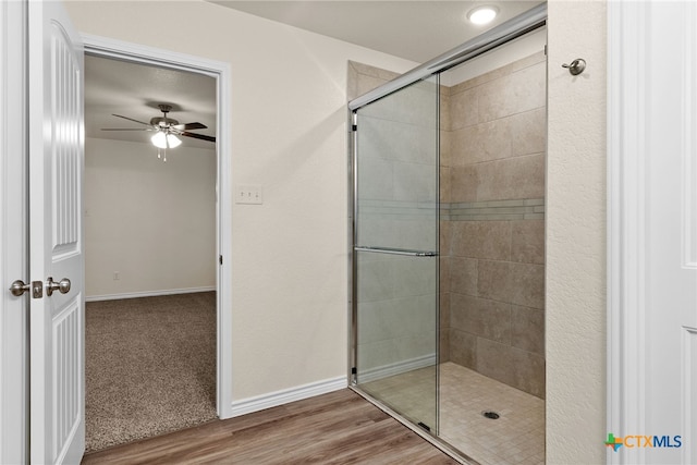 bathroom featuring hardwood / wood-style floors, an enclosed shower, and ceiling fan