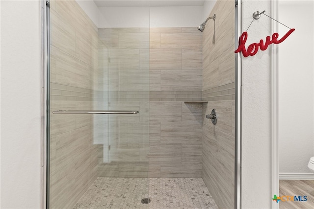 bathroom featuring tiled shower and toilet