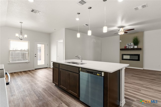 kitchen featuring an island with sink, dark brown cabinets, sink, and stainless steel dishwasher