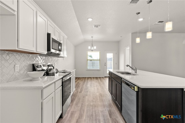 kitchen featuring sink, hanging light fixtures, white cabinets, and stainless steel appliances