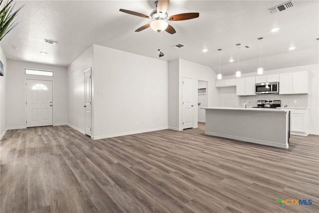 kitchen with tasteful backsplash, light stone counters, a chandelier, a textured ceiling, and lofted ceiling