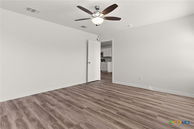 spare room with ceiling fan and dark wood-type flooring