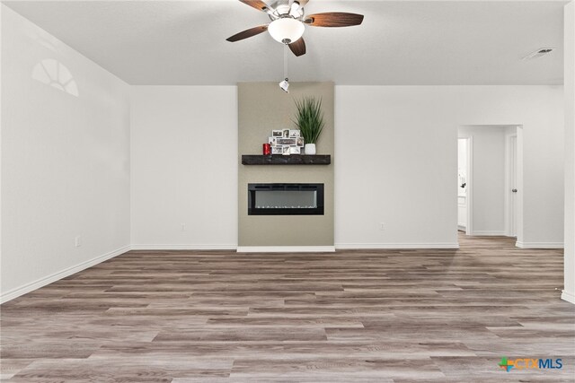 unfurnished living room featuring ceiling fan with notable chandelier