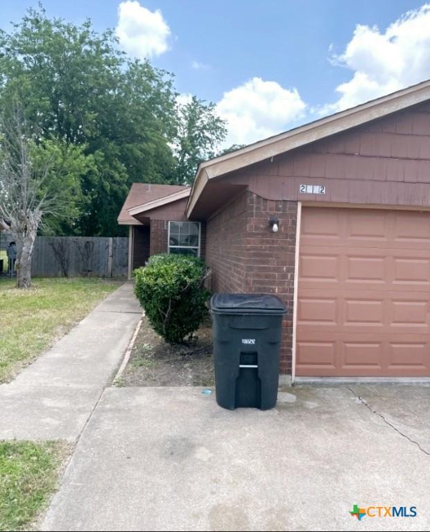 view of side of home with a yard and a garage