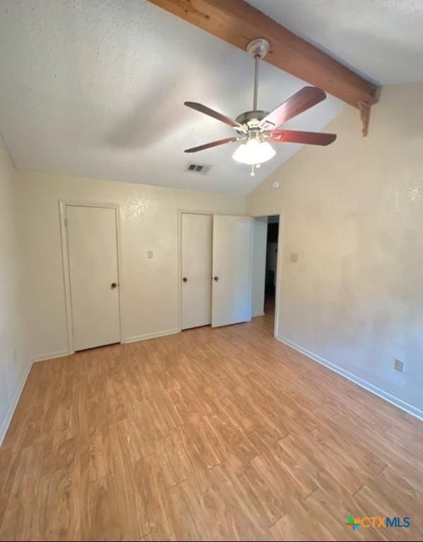 unfurnished bedroom featuring lofted ceiling with beams, a textured ceiling, ceiling fan, and light hardwood / wood-style flooring