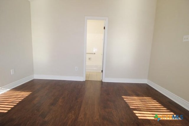 empty room with dark hardwood / wood-style flooring