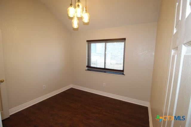 unfurnished room featuring vaulted ceiling, an inviting chandelier, and dark wood-type flooring