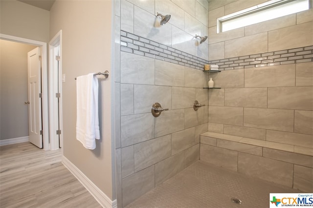 bathroom featuring tiled shower and hardwood / wood-style flooring