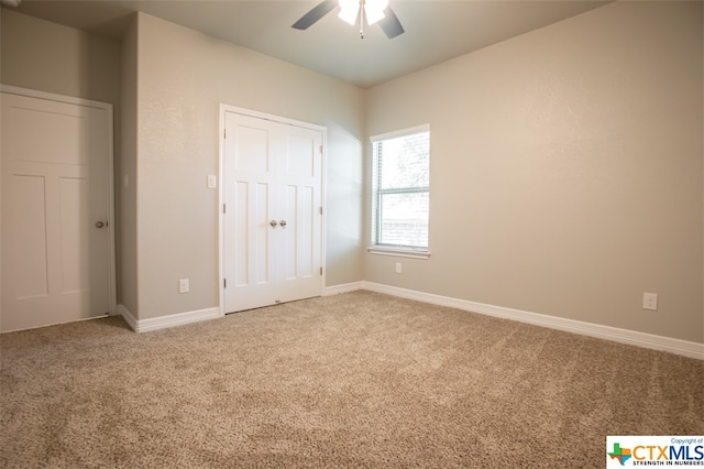 unfurnished bedroom featuring ceiling fan and carpet floors