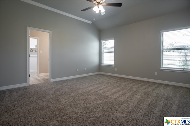 carpeted empty room with plenty of natural light, ceiling fan, crown molding, and vaulted ceiling