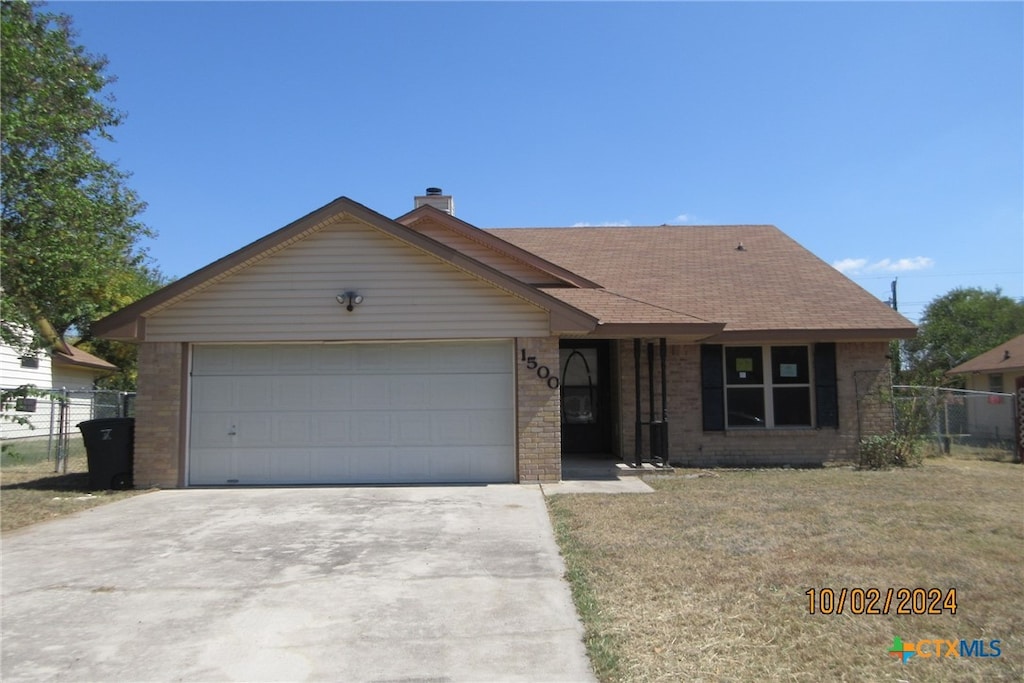 ranch-style house featuring a garage and a front yard