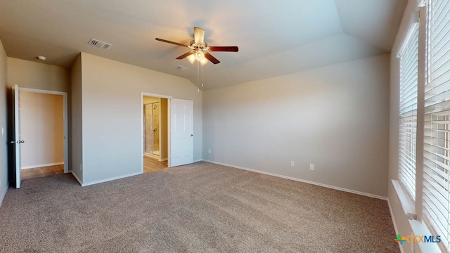 unfurnished bedroom featuring ceiling fan, lofted ceiling, and light colored carpet