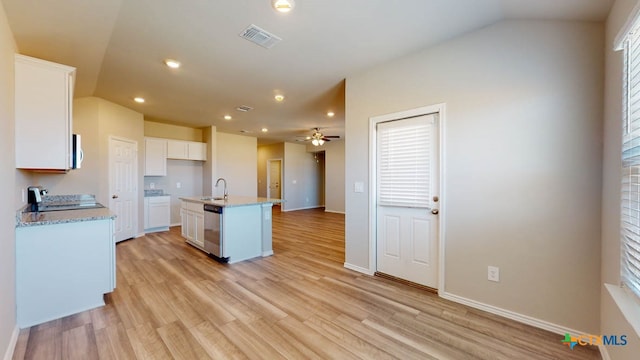 kitchen featuring a center island with sink, light stone counters, stainless steel dishwasher, white cabinetry, and light hardwood / wood-style flooring