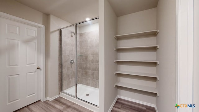 bathroom featuring hardwood / wood-style floors and a shower with shower door