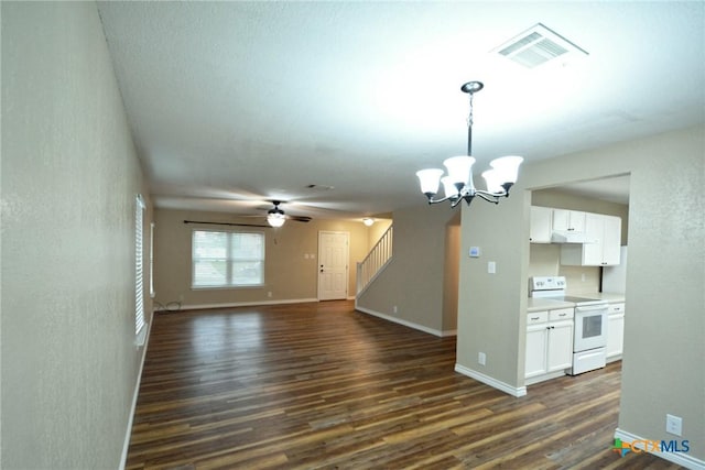 unfurnished living room with ceiling fan with notable chandelier, visible vents, baseboards, dark wood-style floors, and stairs