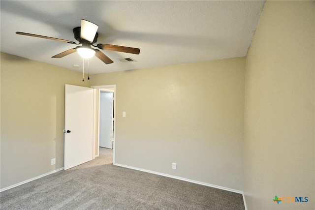 empty room featuring baseboards, visible vents, ceiling fan, and carpet floors
