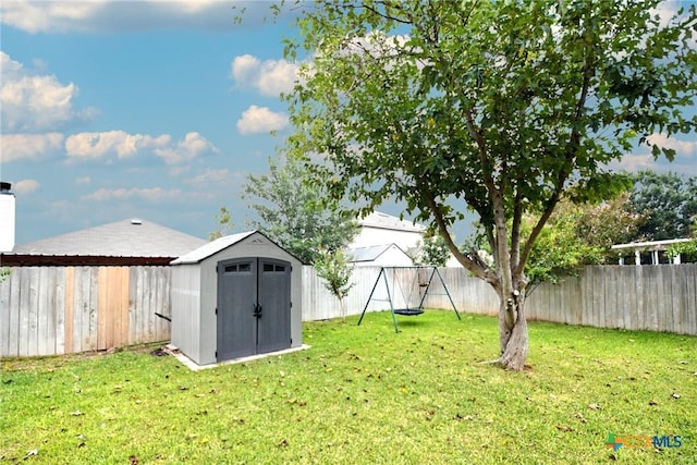 view of yard featuring a fenced backyard, a storage shed, and an outdoor structure