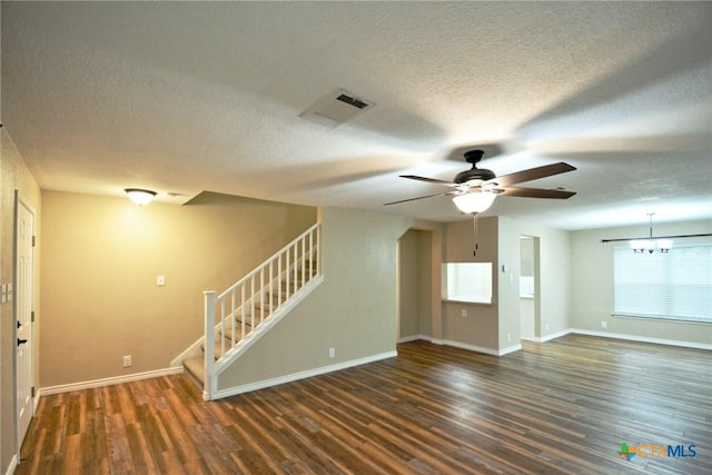 unfurnished living room with stairs, a textured ceiling, visible vents, and wood finished floors