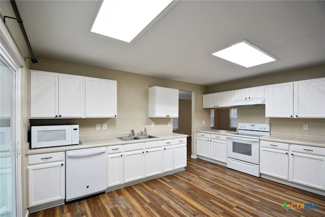 kitchen featuring dark wood finished floors, white cabinetry, a sink, and white appliances