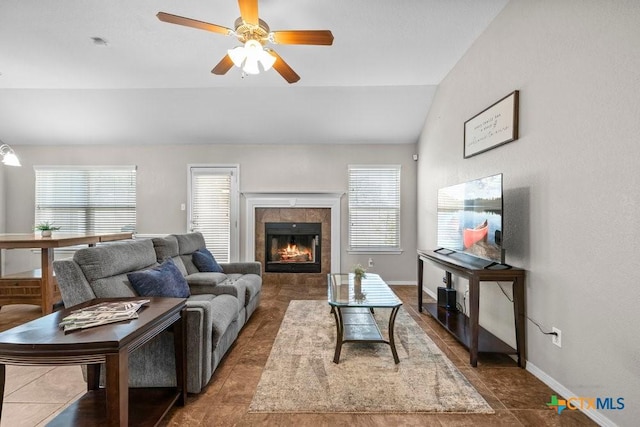 7621 Amber Meadow Loop, Temple, TX 76502 - living area featuring lofted ceiling, healthy amount of natural light, baseboards, a ceiling fan, and a tiled fireplace