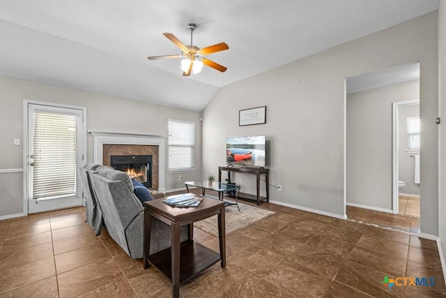 7621 Amber Meadow Loop, Temple, TX 76502 - tiled living room with a tiled fireplace, ceiling fan, vaulted ceiling, and baseboards