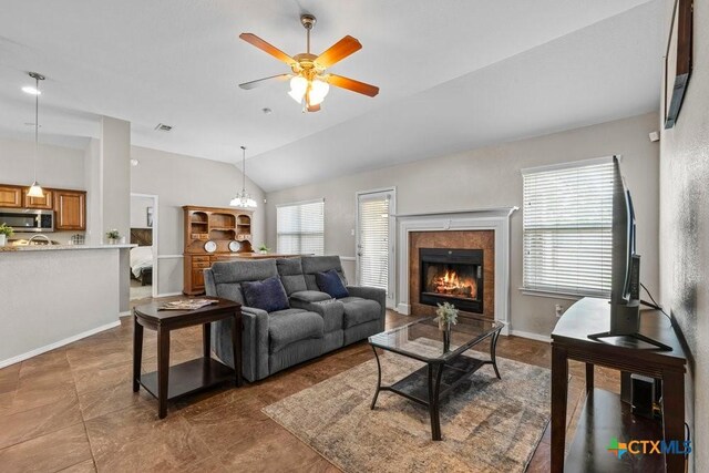 7621 Amber Meadow Loop, Temple, TX 76502 - living area with vaulted ceiling, plenty of natural light, ceiling fan, a tile fireplace, and baseboards