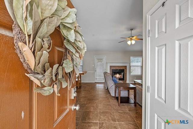 7621 Amber Meadow Loop, Temple, TX 76502 - entryway featuring a warm lit fireplace, a ceiling fan, and dark tile patterned flooring