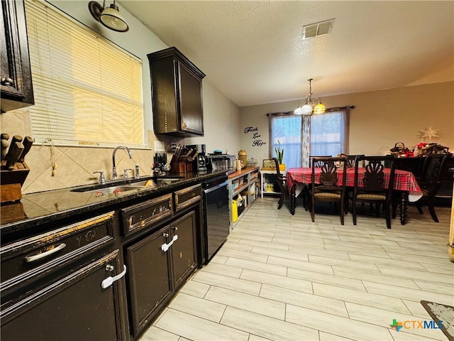 kitchen featuring pendant lighting, sink, black dishwasher, a notable chandelier, and dark brown cabinetry