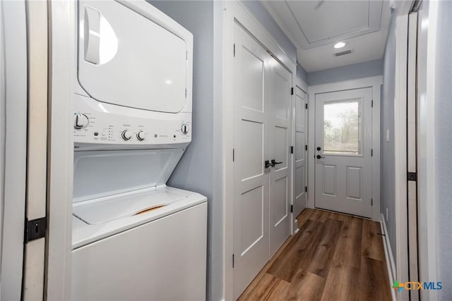 washroom featuring wood-type flooring and stacked washer and clothes dryer