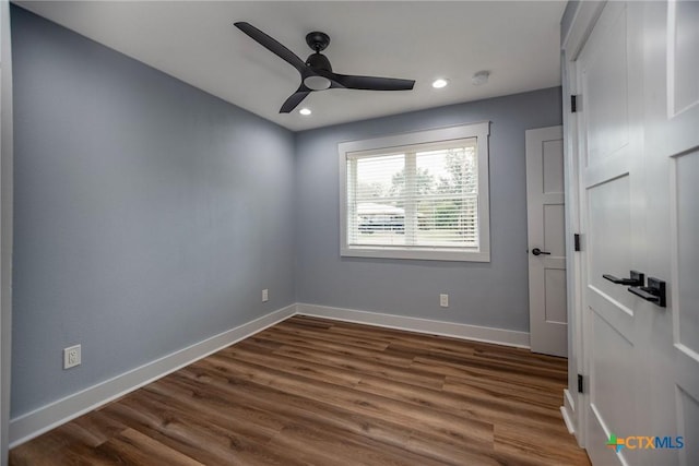 spare room featuring ceiling fan and dark hardwood / wood-style flooring