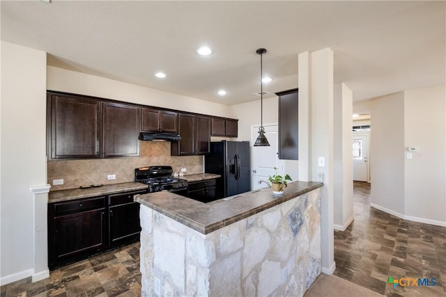 kitchen with dark brown cabinetry, decorative backsplash, decorative light fixtures, under cabinet range hood, and black appliances