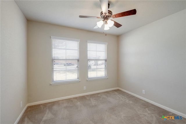 spare room with ceiling fan, carpet floors, and baseboards