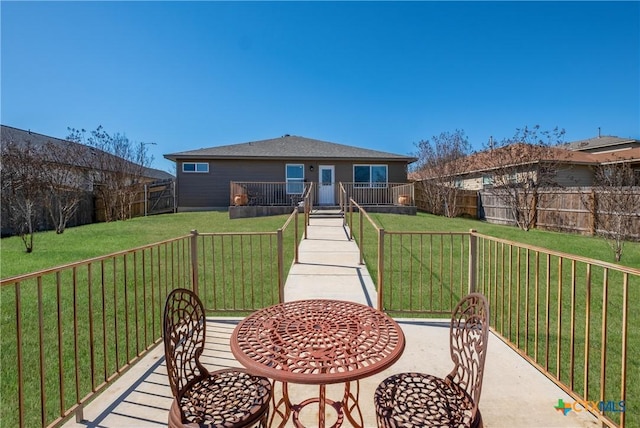 back of property with a fenced backyard and a lawn