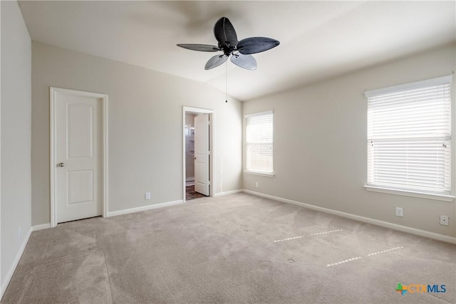 unfurnished bedroom with carpet floors, lofted ceiling, ceiling fan, ensuite bath, and baseboards