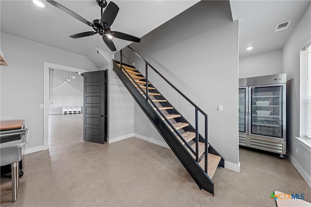 stairs featuring ceiling fan, beverage cooler, and concrete flooring