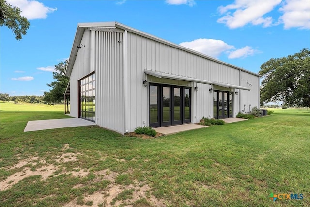 back of property with a lawn and french doors