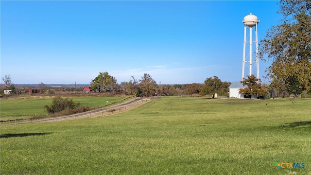 view of home's community with a rural view and a yard