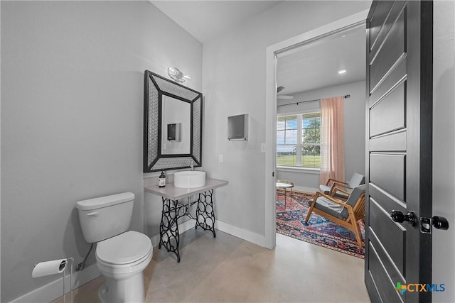 bathroom featuring toilet and concrete flooring