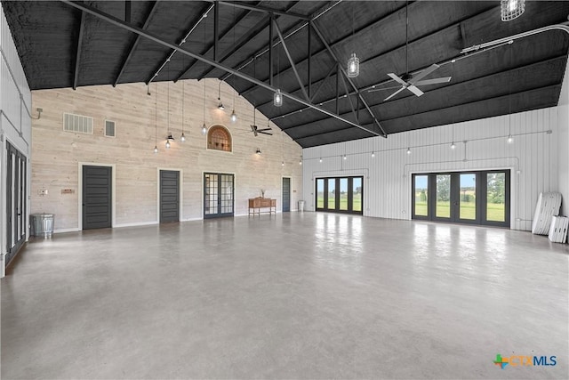 garage featuring ceiling fan and wood walls