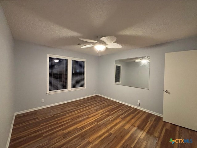 unfurnished room with dark hardwood / wood-style floors, a textured ceiling, and ceiling fan