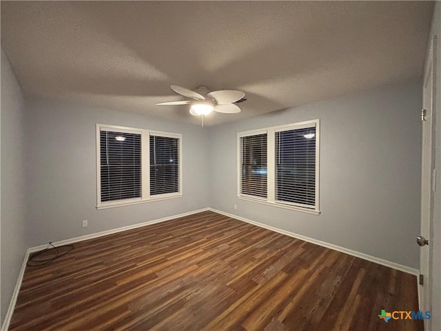 unfurnished room with ceiling fan, dark wood-type flooring, and a textured ceiling