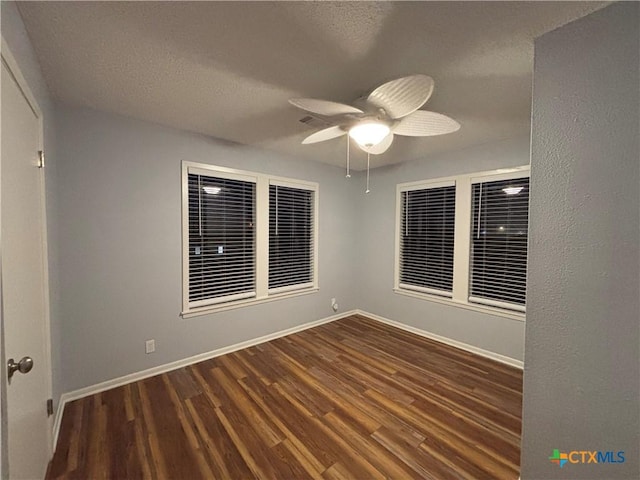 unfurnished room featuring dark wood-type flooring, a textured ceiling, and ceiling fan